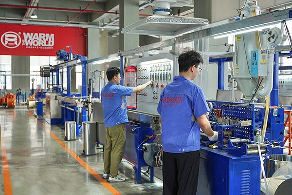 工人在操作電伴熱帶護(hù)套擠出設(shè)備 環(huán)瑞電熱供圖